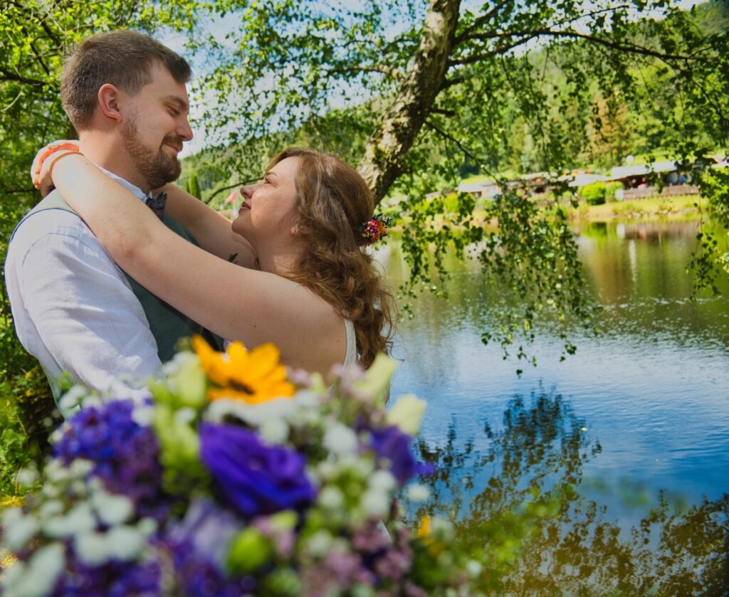 Romantisches Brautpaar am Ufer des Kurweihers in Bad Schwalbach, Spiegelung im Wasser, sanftes Abendlicht. #KurweiherLiebe