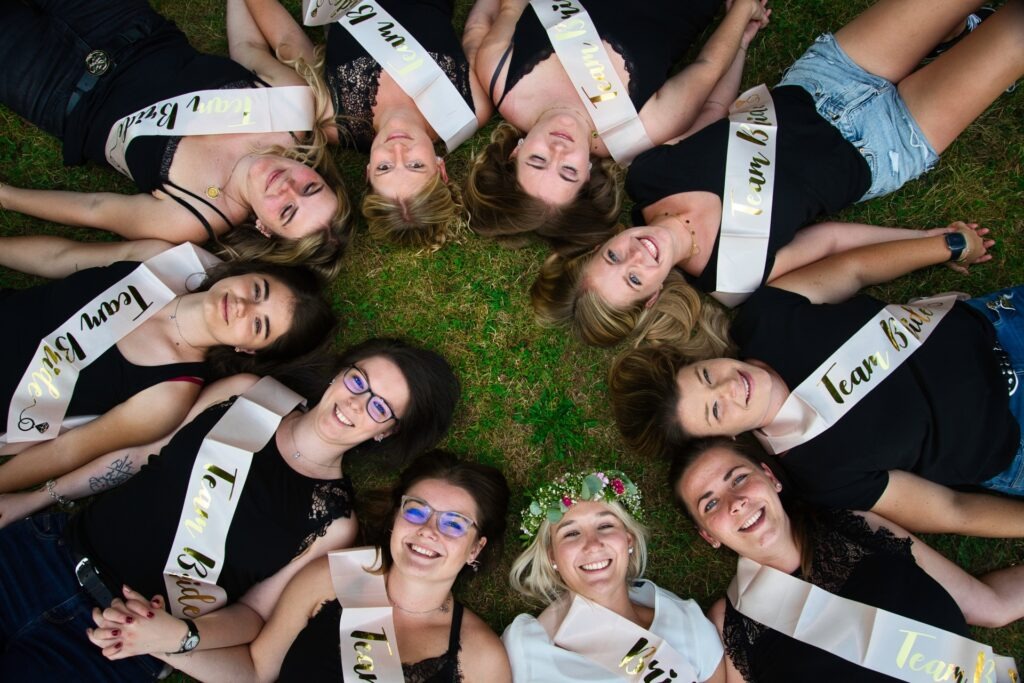 Jungesellinen Abschied alle liegen auf der Wiese und schauen nach oben in die Kamera.