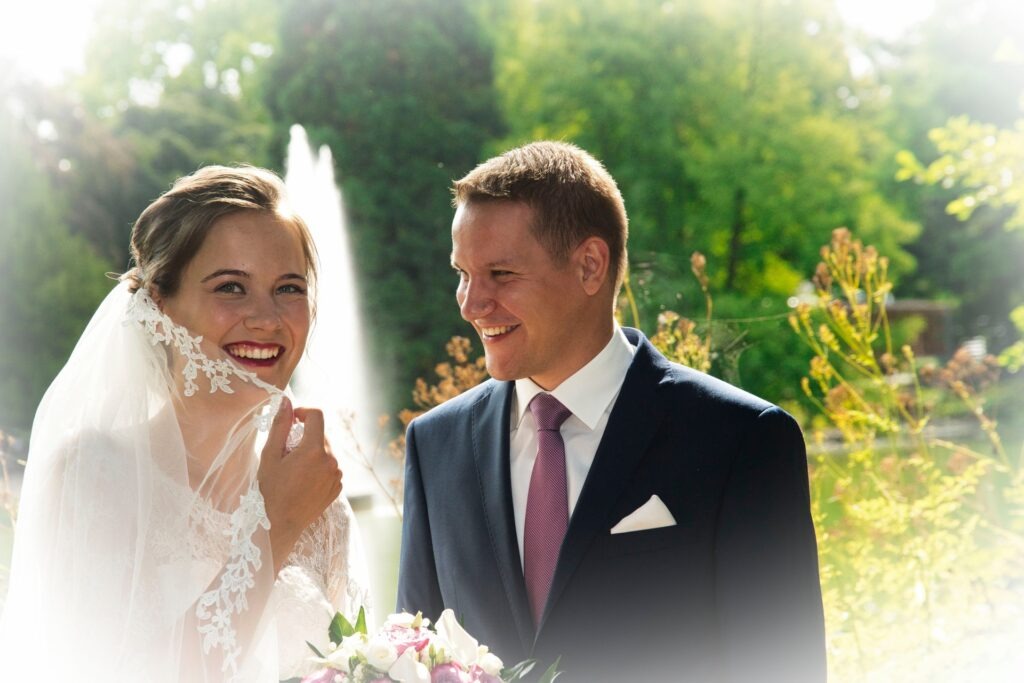 Detailbild des Brautpaares, umgeben von farbenprächtigen Blumen und Beeten, Fokus auf die Freude und Frische des Tages.