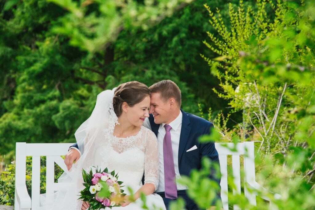 Detailbild des Brautpaares, umgeben von farbenprächtigen Blumen und Beeten, Fokus auf die Freude und Frische des Tages.