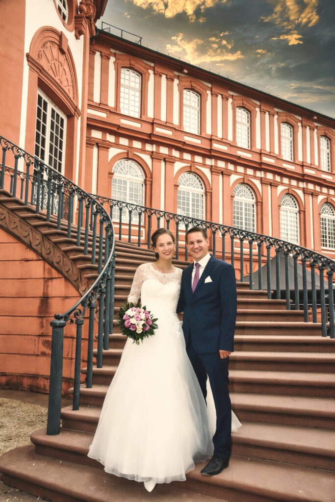 Brautpaar steht auf der freitreppe vom schloss biebrich in wiesbaden